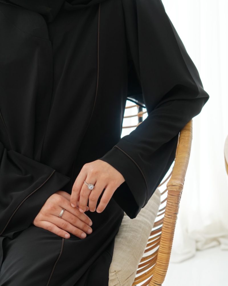 Sleek black abaya with contrast piping accents, combining contemporary design with modest fashion
